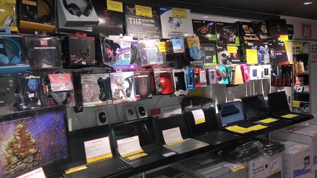 Display of laptops and gaming accessories in a computer shop.