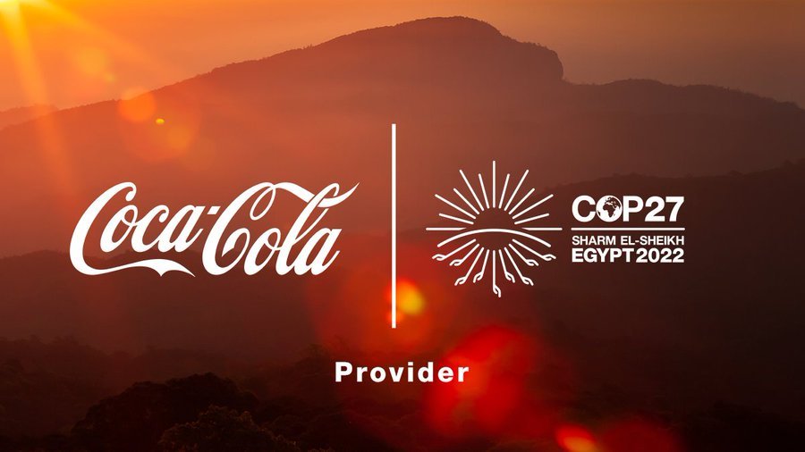 Coca-Cola logo and COP27 emblem against a mountain sunset background, symbolizing the greenwashing controversy.