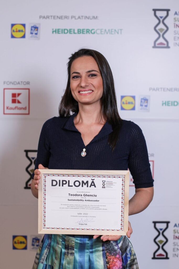 Teodora Ghenciu, Sustainability Ambassador, holding her diploma at an event.
