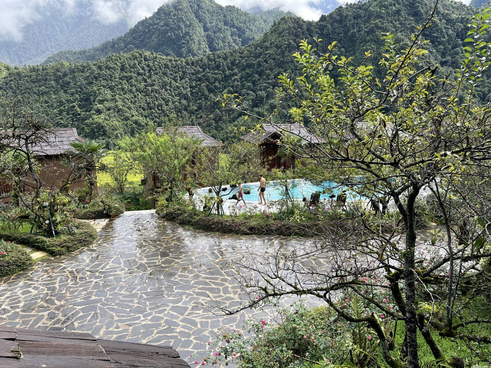 Lush mountain landscape with pools and traditional houses in Vietnam.
