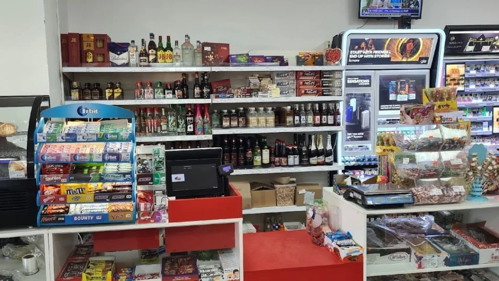 Shelves with drinks and sweets in a small neighborhood store.
