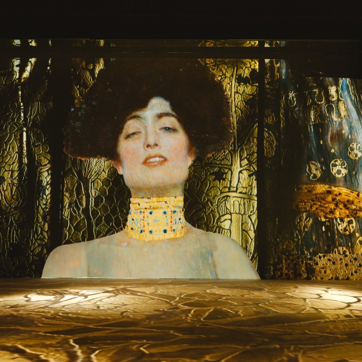 An artistic projection featuring a woman with a decorative golden background, blending art and technology.