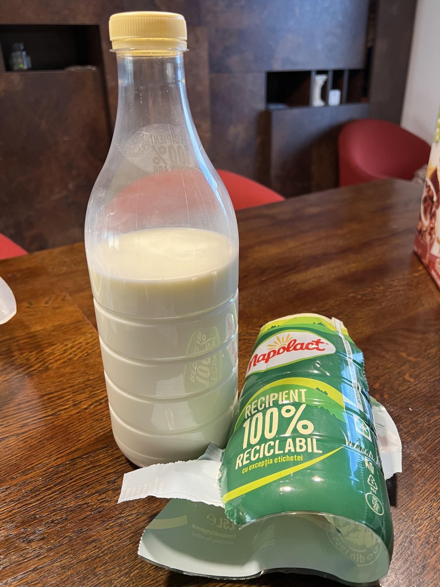 Napolact milk packaging in a white bottle and green recyclable wrapper.